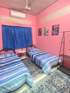 two beds in a room with pink and blue at Hostel Qamaar in Langkawi Intl +30 photos