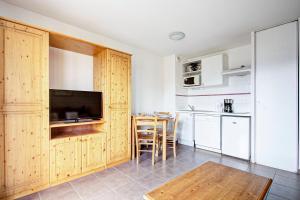 eine Küche mit einem Tisch und einem TV im Zimmer in der Unterkunft L'Escapade aux Angles - Proche Stations in Les Angles