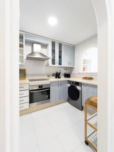 una cucina con armadietti bianchi e lavastoviglie nera di Ulises La Perla a Calahonda