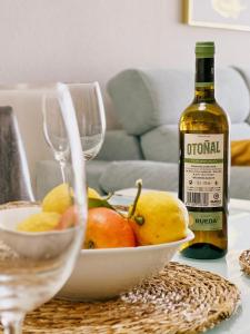 un tavolo con una ciotola di frutta e una bottiglia di vino di Ulises La Perla a Calahonda