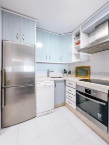 una cucina con armadi blu e frigorifero in acciaio inossidabile di Ulises La Perla a Calahonda Altre 17 foto