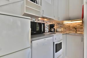 a kitchen with white cabinets and a white refrigerator at Holiday Apartment Yllästokka 2 in Ylläsjärvi