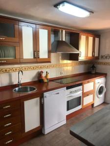 a kitchen with wooden cabinets and white appliances at Charming Villa in Punta Umbría with Private Pool in Punta Umbría
