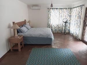 a bedroom with a bed and a table and a window at Pennington Beach Cottage Holiday accommodation in Pennington