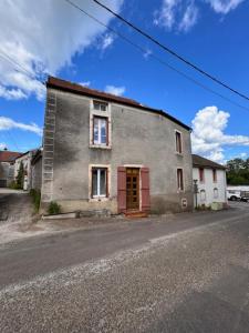 a building with a red door on the side of a street at Le Premeaux, au cœur des vignes in Prémeaux