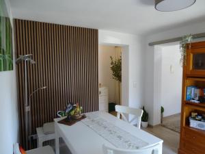 a dining room with a white table and chairs at Ferienwohnung am Pilsensee in Seefeld