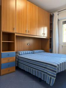 a bedroom with two beds and wooden cabinets at App4rent - VILLA MIMOSA - 3 Family apartments - parking, wifi, near the beach in Lido di Jesolo