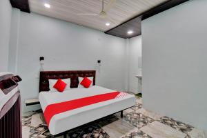 - une chambre avec un lit doté d'oreillers rouges dans l'établissement Hotel O The Village Resort, à Itwāri