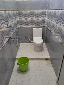 baño con aseo y cubo verde en Anuj Palace, en Ayodhya