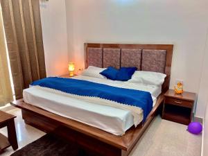 a bedroom with a large bed with blue sheets at Hotel VASURAI and RESTAURANT in Nākuri