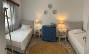 a bedroom with two beds and a blue dresser at Calliope's house in Skiros