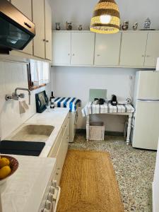 a kitchen with white cabinets and a sink and a refrigerator at Calliope's house in Skiros
