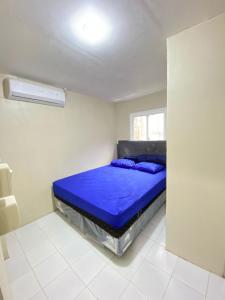 a bedroom with a blue bed in a white room at Penginapan Bintang Timur PANTAI KAMALI in Baubau +9 photos