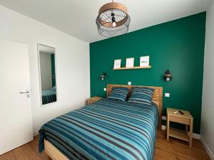 a bedroom with a bed with a green wall at Maison de vacances 6 personnes près de Bordeaux Green Escape in Cenon