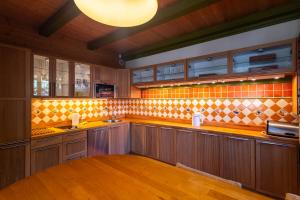 a large kitchen with wooden cabinets and a counter top at Victus Apartamenty, Fisherman's House - Chata Rybaka in Sopot