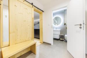 a bathroom with a wooden door and a bench at Jasmínový Ráj in Vítkovice +62 photos
