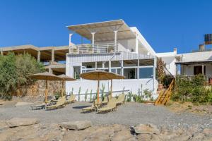 a group of chairs and umbrellas in front of a house at VistaMare2 Double room-sea view in Koutsourás