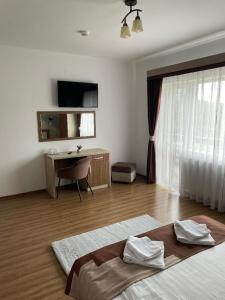 a bedroom with a bed and a desk and a window at Villa Prestige in Sovata