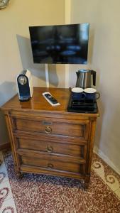 - une commode en bois avec deux bols et une télévision dans l'établissement La villa des figuiers, à Saint-Bonnet-du-Gard