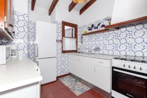 una cucina con elettrodomestici bianchi e una parete piastrellata di Cavall Menor a Cala Morell