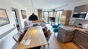 ein Wohnzimmer mit Tisch und Couch in der Unterkunft Ocean House Garten Eden mit Whirlpool in Timmendorfer Strand