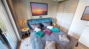 ein Schlafzimmer mit einem blauen Bett und bunten Kissen in der Unterkunft Ocean House Garten Eden mit Whirlpool in Timmendorfer Strand