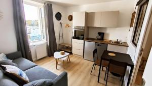 a living room with a couch and a table and a kitchen at Le Prince de Guerveur - Studio in Sauzon