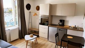 a small kitchen with a table and a dining room at Le Prince de Guerveur - Studio in Sauzon