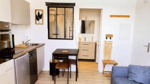 a small kitchen with a table and a blue couch at Le Prince de Guerveur - Studio in Sauzon