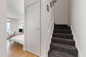 a hallway with a stairway leading to a bedroom at Chic 2BR Loft Near Melbourne Central Free Parking in Melbourne