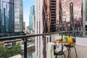 a balcony with a table and chairs in a city at Chic 2BR Loft Near Melbourne Central Free Parking in Melbourne