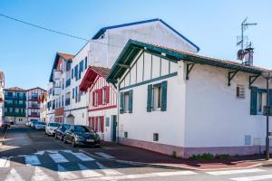 a group of buildings on a street with cars parked at Maison de ville in Saint-Jean-de-Luz
