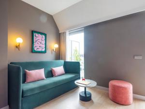 リスボンにあるNuma Lisbon Ratoのリビングルーム(緑のソファ、ピンクのスツール付)