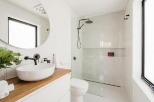 a white bathroom with a sink and a shower at Tree Top Treasure Itas in Kings Meadows +56 photos