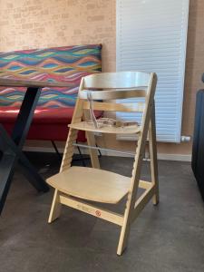 a wooden chair sitting next to a table and a bed at Haus Mariechen Whg 2- 5-Sterne-DTV-Klassifizierung- nähe Silbersee mit Terrasse & Sauna, in Frielendorf