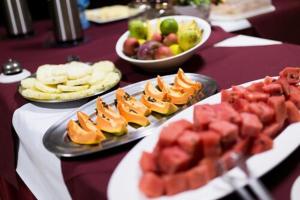 a table topped with plates of fruit and snacks at OYO Pousada Paraná, Cuiabá in Cuiabá