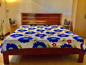 a bed with a floral comforter on it at Fortune Villas in Trou dʼ Eau Douce +13 photos