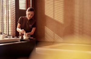 a woman standing in a kitchen preparing food at The Peninsula Bangkok in Bangkok +56 photos