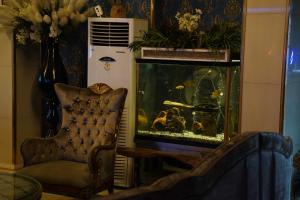 a living room with a fish tank and a chair at Safir Hotels Silivri in Silivri