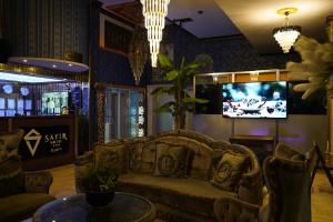 a living room with a couch and a tv at Safir Hotels Silivri in Silivri