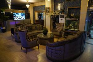 a living room with couches and chairs and a tv at Safir Hotels Silivri in Silivri