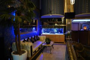 a living room with a couch and a palm tree at Safir Hotels Silivri in Silivri