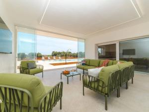 een woonkamer met groene meubels en een groot raam bij Villa Donnosanto a 5 Minuti Da Spiaggia. Ostuni 10 in Carovigno