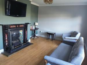 a living room with a couch and a fireplace at Belleek Lodge in Ballina