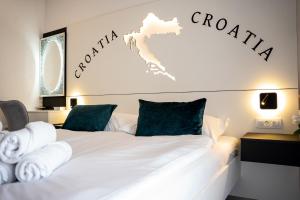 a bedroom with a white bed with a sign that reads croatia at Villa Istra Relax Smaragd for 8 people with heated pool & pet friendly only 800 m from the beach in Rebići