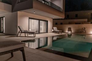 a house with a swimming pool with two chairs at Villa Istra Relax Smaragd for 8 people with heated pool & pet friendly only 800 m from the beach in Rebići