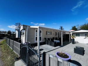 een klein huis met een hek en een patio bij RBR 662 - Beach Resort Kamperland in Kamperland