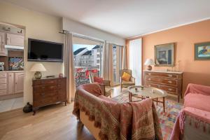 a living room with a tv and a couch and a table at Appartement pour 4 au Pouliguen, avec terrasse in Le Pouliguen
