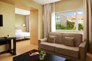 a living room with a couch and a window at NH Madrid Ribera del Manzanares in Madrid