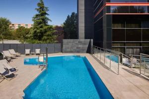 a swimming pool on the roof of a building at NH Madrid Ribera del Manzanares in Madrid +26 photos